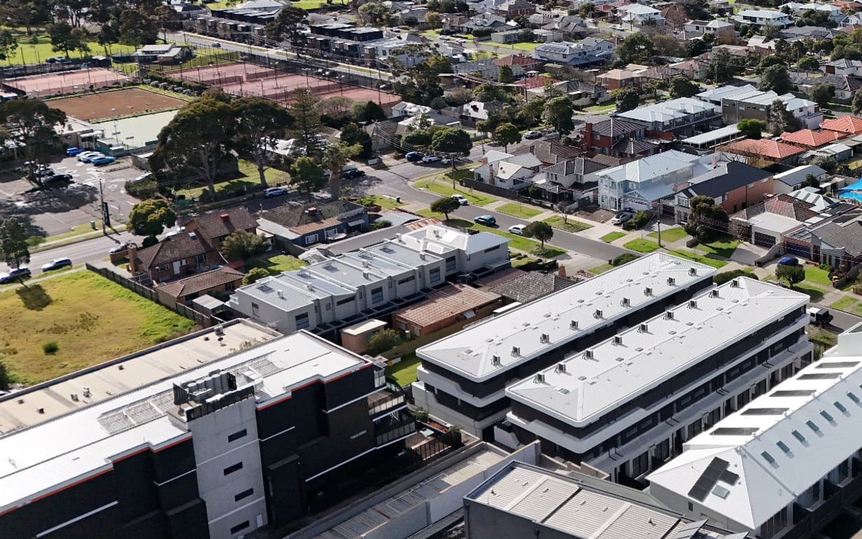 A real street block from our own shoot before any clean-up: parked cars and rooftop plant still in the photo.