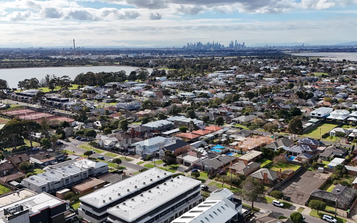 A real drone photo from our own shoot before any relight: houses, lake, city skyline and sky exactly as photographed.